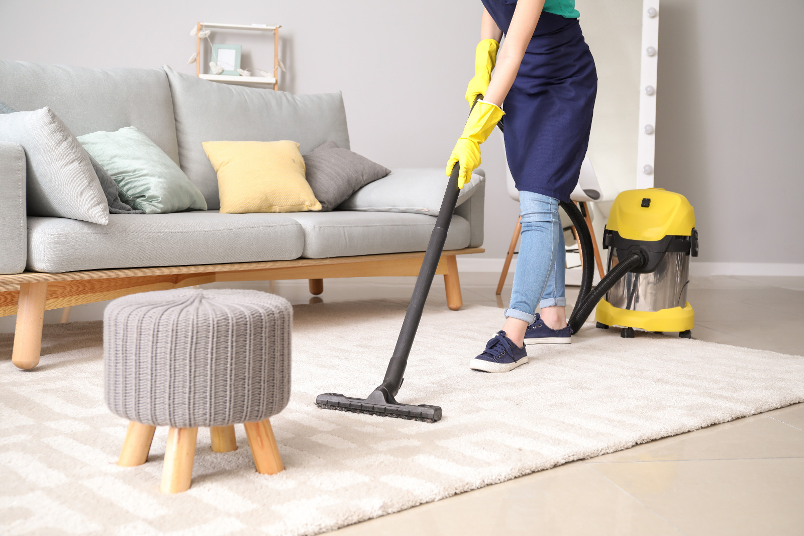 Professional cleaner vacuuming a living room